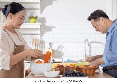 A woman prepares fresh vegetables in a cozy kitchen, while a man assists in the background. The scene emphasizes a warm and healthy lifestyle with a focus on fresh produce and home cooking. - Powered by Shutterstock