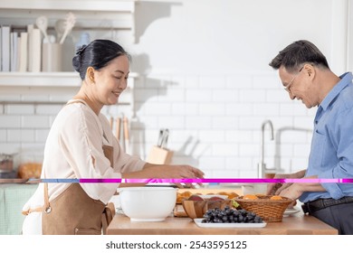 A woman prepares fresh vegetables in a cozy kitchen, while a man assists in the background. The scene emphasizes a warm and healthy lifestyle with a focus on fresh produce and home cooking. - Powered by Shutterstock