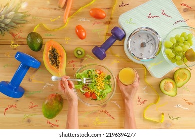 Woman prepares a healthy meal with salad and orange juice - Shutterstock ID 2196394277