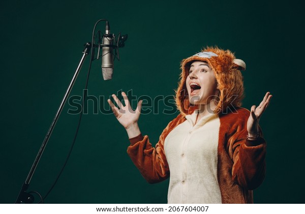 Woman\
prepares herself and a material before voice recording. Soundproof\
room for professional recording vocal. Voice artist works with\
material before dubbing or voice over\
process