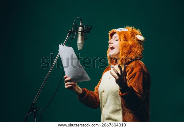 Woman\
prepares herself and a material before voice recording. Soundproof\
room for professional recording vocal. Voice artist works with\
material before dubbing or voice over\
process