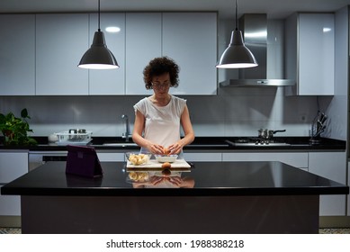 Woman Preparing Banana Pancakes In The Kitchen At Night