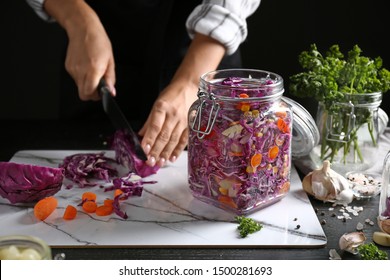 Woman preparing cabbage for fermentation at table, closeup - Powered by Shutterstock