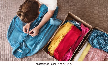 Woman preparing clothes for clothing swap. Concept of waste problem in fashion industry.