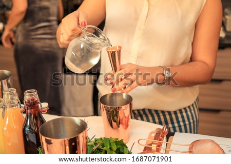 Woman preparing a cocktail at a home party.