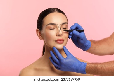 Mujer preparándose para cirugía estética, de fondo rosado. Doctor dibujando marcas en su cara, cerrando