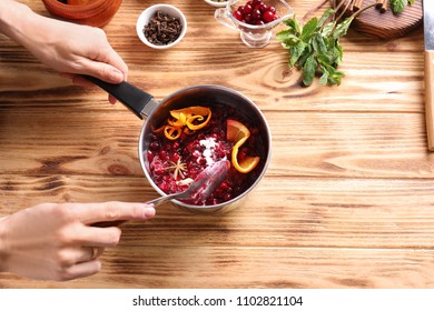 Woman Preparing Delicious Cranberry Sauce At Table, Top View