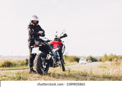 Woman preparing to drive a motorbike. Roadside break, wearing gloves - Powered by Shutterstock