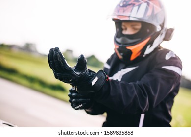 Woman preparing to drive a motorbike. Wearing gloves on a roadside - Powered by Shutterstock