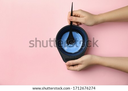 Woman preparing dye for hair coloring on pink background, top view. Space for text