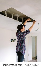 Woman Preparing Extractor Hood Installation On Kitchen Ceiling