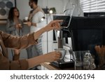 Woman preparing fresh aromatic coffee with modern machine in office, closeup