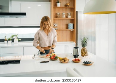 Woman Preparing Fresh Fruit for a Smoothie in a Modern Kitchen - Powered by Shutterstock