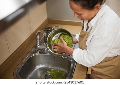 Woman preparing fresh greens in a modern kitchen setting - Powered by Shutterstock