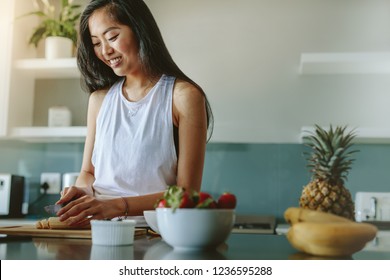 Woman Preparing Healthy Salad From Fresh Fruits In The Kitchen. Female Making Healthy Breakfast In The Morning After Workout.