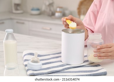 Woman Preparing Infant Formula At Table Indoors, Closeup. Baby Milk