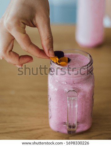 Similar – Mann hält einen Milchshake aus Beeren und Haferflocken.