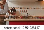 Woman preparing meal in cozy kitchen with festive decorations