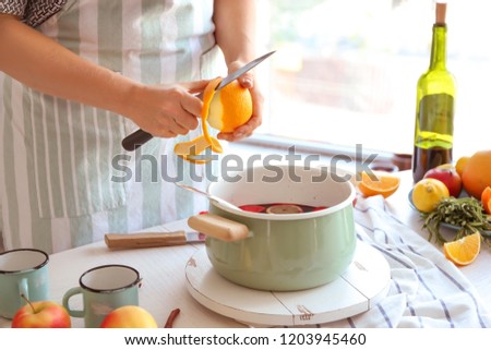 Woman preparing mulled wine at table