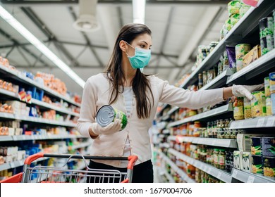 Woman Preparing For Pathogen Virus Pandemic Spread Quarantine.Choosing Nonperishable Food Essentials.Budget Buying At A Supply Store.Pandemic Quarantine Preparation.Emergency To Buy List