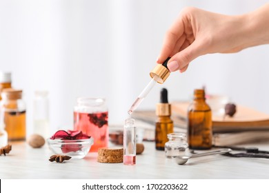 Woman preparing perfume on table