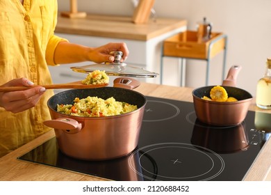 Woman preparing pilaf in cooking pot