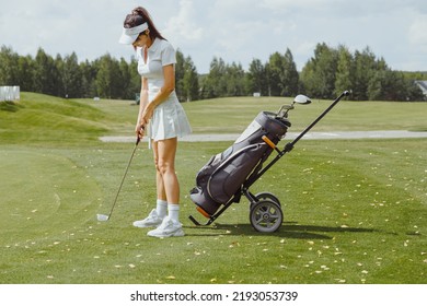 Woman Preparing To Putt On Golf Course