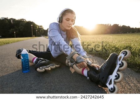 Woman preparing to rollerblade in the park
