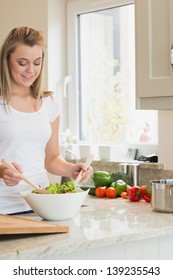 Woman preparing salad in kitchen