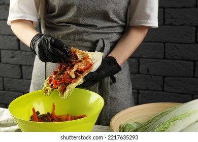 Woman Preparing Spicy Cabbage Kimchi At Wooden Table Indoors, Closeup