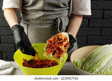 Woman Preparing Spicy Cabbage Kimchi At Wooden Table Indoors, Closeup