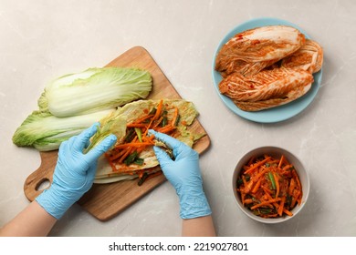 Woman Preparing Spicy Cabbage Kimchi At Beige Marble Table, Top View