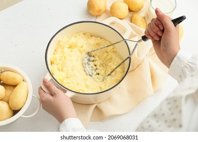 Woman preparing tasty mashed potatoes on light background, closeup - Shutterstock ID 2069068031