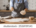 Woman preparing traditional cinnamon rolls in kitchen