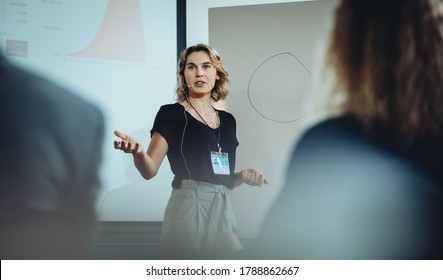 Woman presenting her idea to colleagues in meeting. Businesswoman public speaking in a conference meeting.