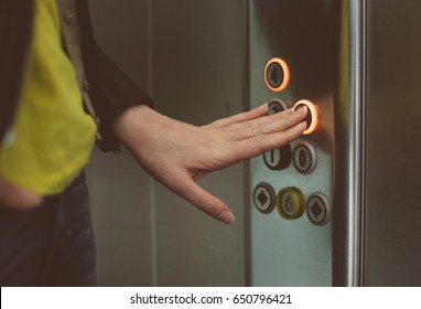 Woman Pressing Button Inside Elevator.