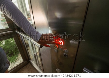 Woman pressing button inside elevator.