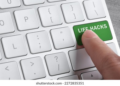 Woman pressing green button with words Life Hacks on computer keyboard, closeup