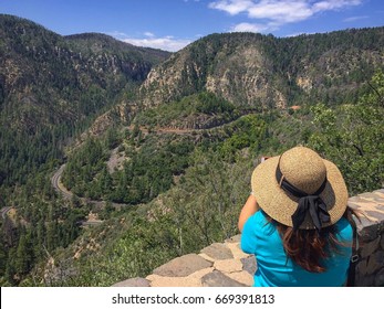 Woman with Pretty Hat Looking at the Oak Creek Canyon Switchback in Sedona, Arizona - Powered by Shutterstock