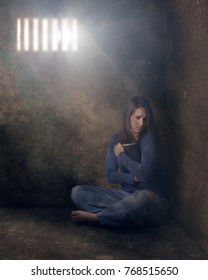 A Woman In Prison Clutching Her Bible.