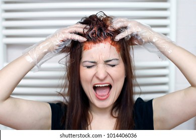 Woman In Process Of Hair Coloring At Home. Applying Red Color To The Hair And Screaming.