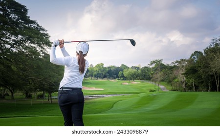 Woman professional golfer under teeing golf hole is competition at golf course for winner with green golf course background. - Powered by Shutterstock