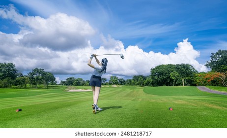 Woman professional golfer under teeing golf to hole is competition at golf course for winner with green golf course background. - Powered by Shutterstock