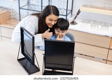 Woman professional optician selling and boy choosing spectacles glasses in optician store. used correct assist or defective eyesight.