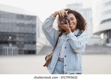 Woman professional photographer with dslr camera outdoors portrait.  Mixed race girl in the city taking pictures. Home hobby, lifestyle, travel, people concept - Powered by Shutterstock