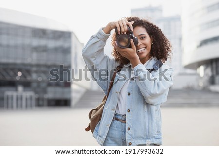Woman professional photographer with dslr camera outdoors portrait.  Mixed race girl in the city taking pictures. Home hobby, lifestyle, travel, people concept