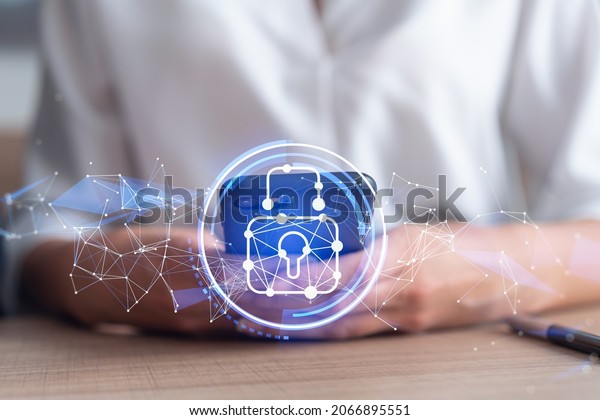 A woman programmer is browsing the Internet in smart\
phone to protect a cyber security from hacker attacks and save\
clients confidential data. Padlock Hologram icons over the typing\
hands. Formal wear