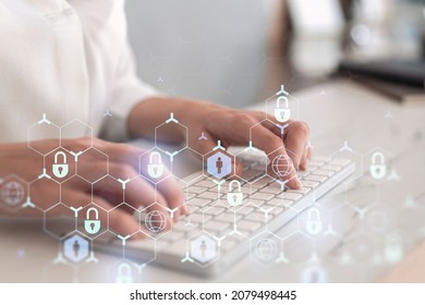 A woman programmer is typing a code on computer to protect a cyber security from hacker attacks and save clients confidential data. Padlock Hologram icons over the typing hands. Formal wear.