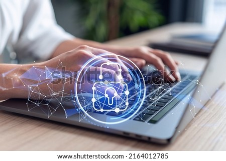 A woman programmer is typing a code on computer to protect a cyber security from hacker attacks and save clients confidential data. Padlock Hologram icons over the typing hands. Formal wear.