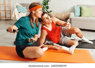 A woman with a prosthetic leg exercises with dumbbells while her boyfriend uses his phone. - Powered by Shutterstock